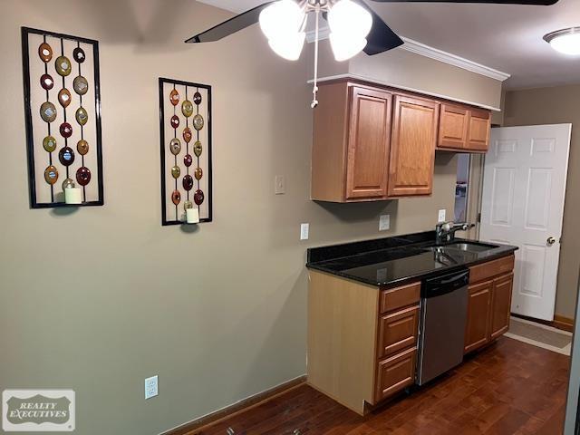 kitchen with crown molding, dark stone counters, stainless steel dishwasher, sink, and ceiling fan