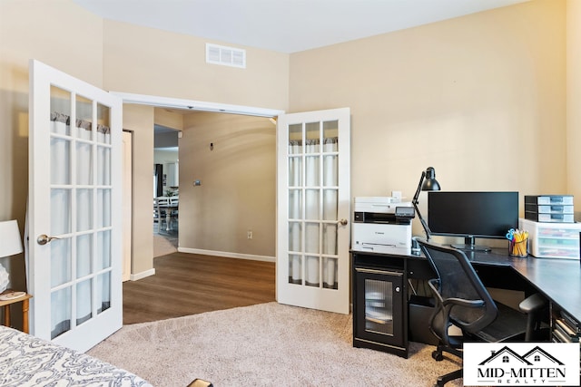 carpeted home office with french doors