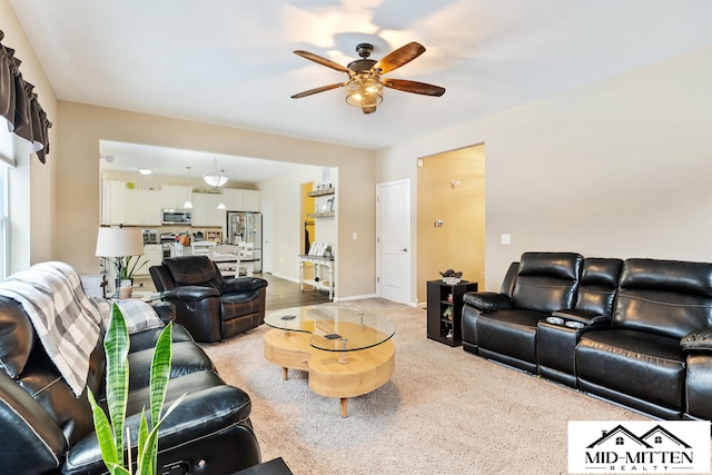 living room with ceiling fan and light colored carpet