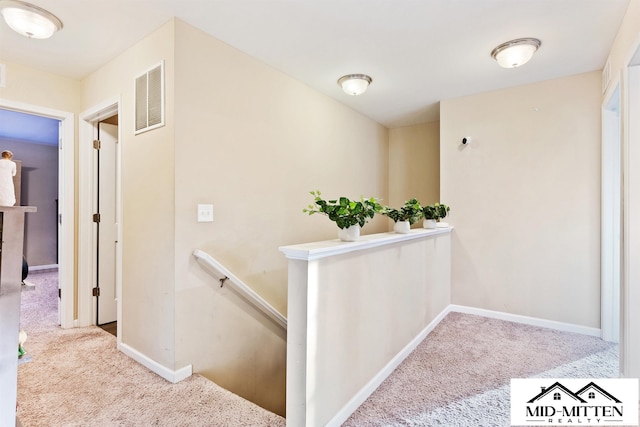 hallway featuring light colored carpet