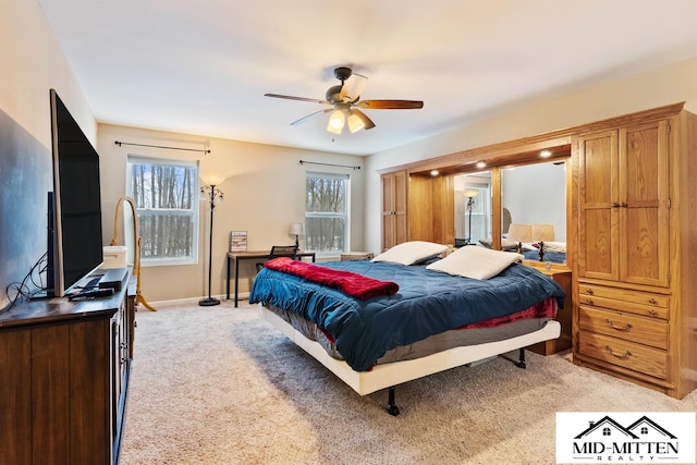 carpeted bedroom with ceiling fan and multiple windows