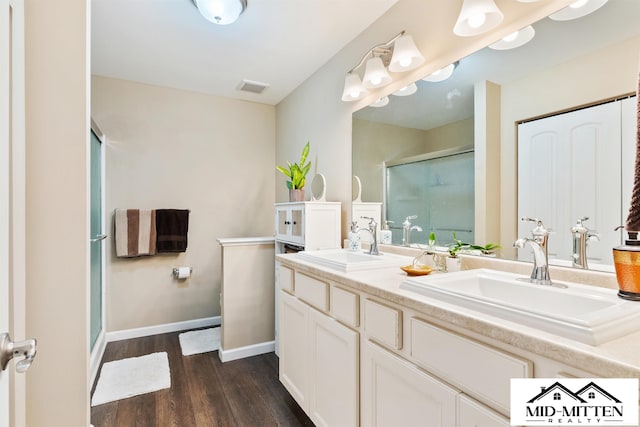 bathroom featuring an enclosed shower, vanity, and wood-type flooring