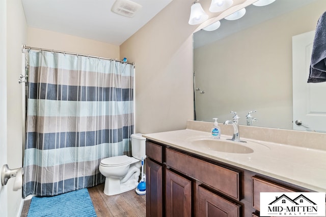 bathroom with toilet, vanity, walk in shower, and hardwood / wood-style flooring