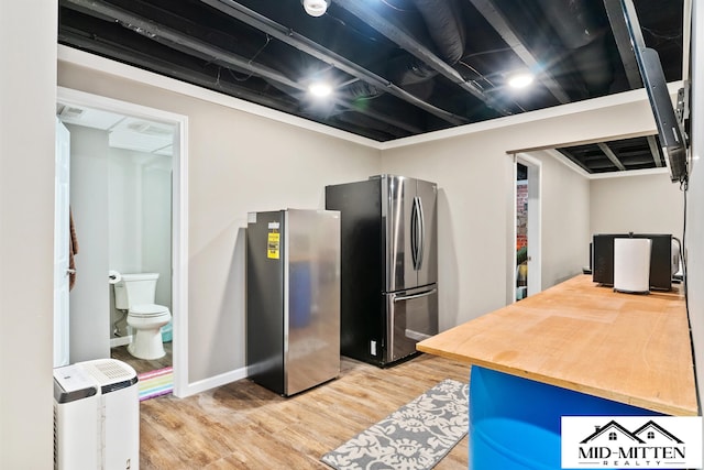 kitchen with hardwood / wood-style floors and stainless steel refrigerator