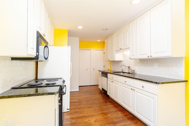 kitchen with tasteful backsplash, hardwood / wood-style flooring, white cabinets, sink, and range with electric stovetop