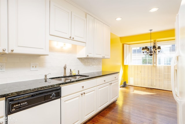 kitchen featuring dark stone countertops, white appliances, white cabinets, and an inviting chandelier