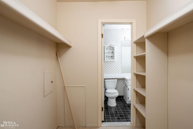 bathroom with toilet and tile patterned floors