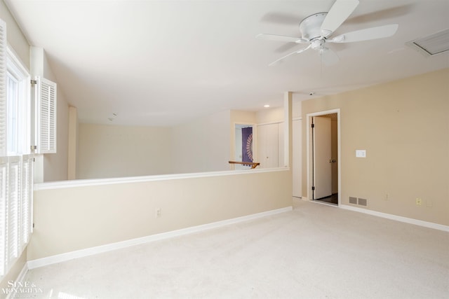 empty room featuring ceiling fan, a healthy amount of sunlight, and light carpet