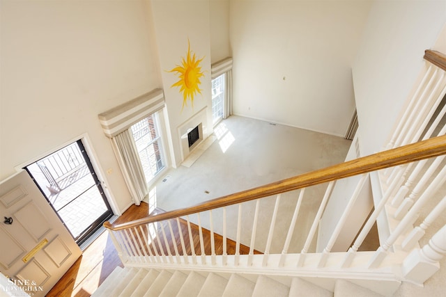 stairs featuring a fireplace and a towering ceiling