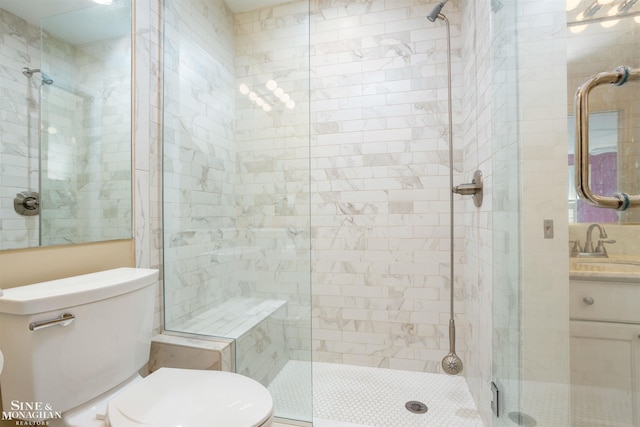 bathroom featuring toilet, a shower with door, and vanity