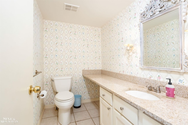 bathroom with toilet, tile patterned floors, and vanity