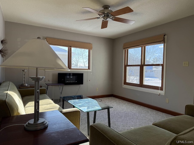 carpeted living room with ceiling fan and a textured ceiling