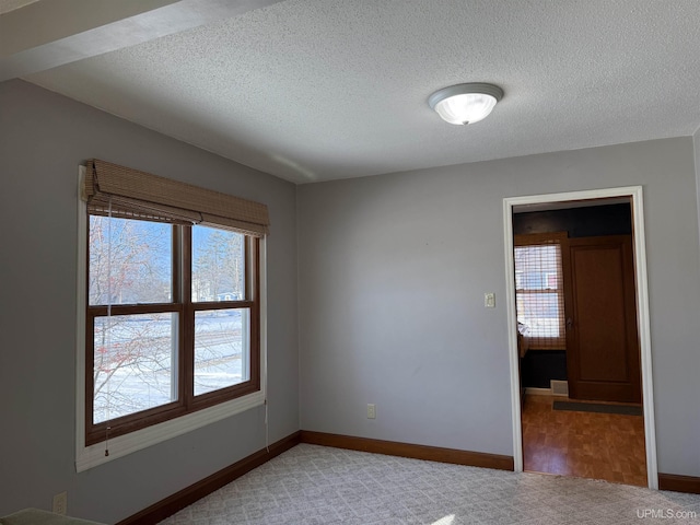 unfurnished room featuring a textured ceiling and carpet flooring