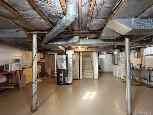 basement with washing machine and dryer, electric panel, and heating unit