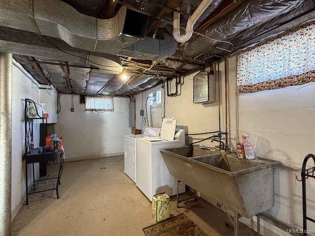 washroom featuring electric panel, washer and dryer, and sink