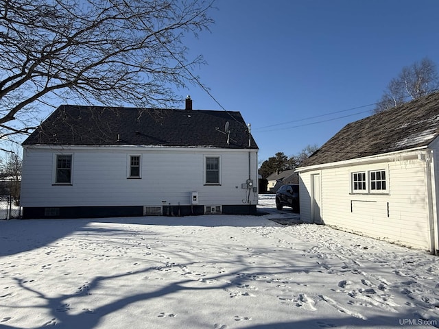 view of snow covered back of property