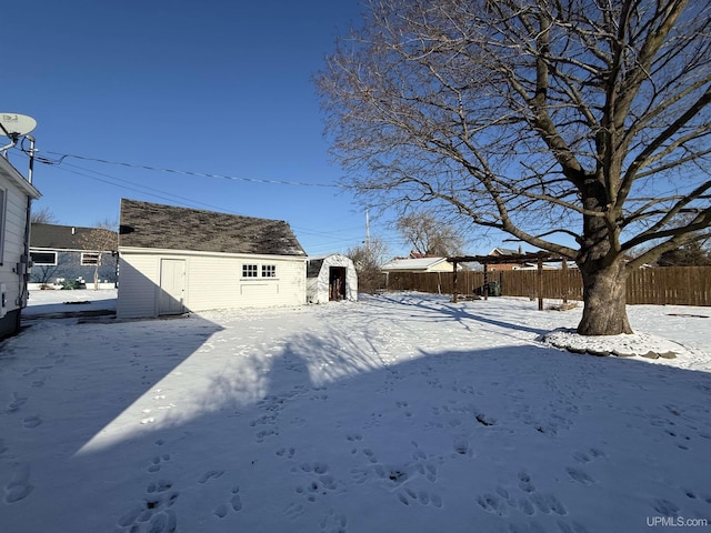 yard layered in snow with a storage shed