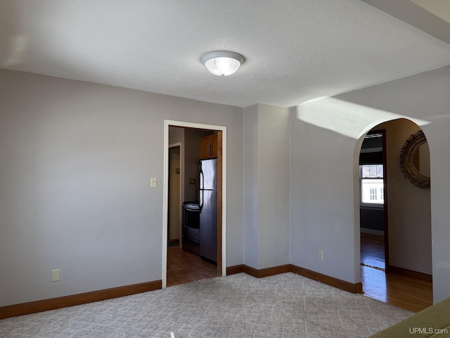 carpeted spare room with a textured ceiling