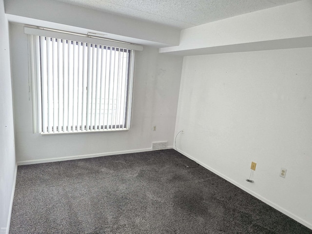 carpeted empty room with a textured ceiling