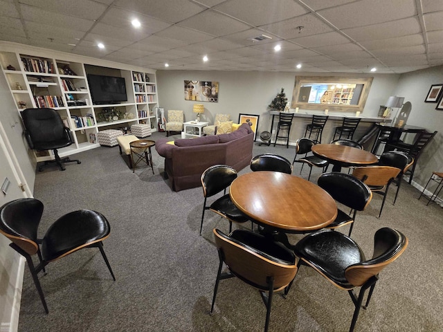 living room with bar, a paneled ceiling, carpet, and built in shelves