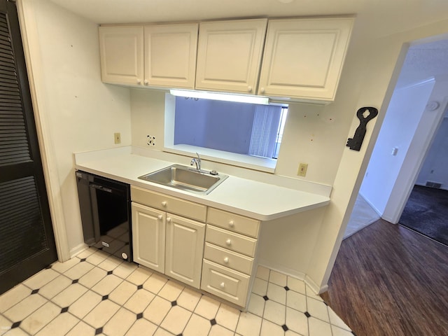 kitchen featuring white cabinets, sink, and black dishwasher