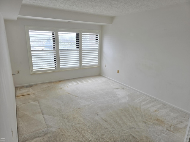 carpeted spare room featuring a textured ceiling