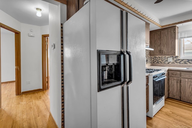 kitchen featuring tasteful backsplash, white appliances, and light hardwood / wood-style floors