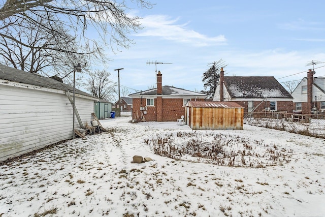 snowy yard with a storage unit