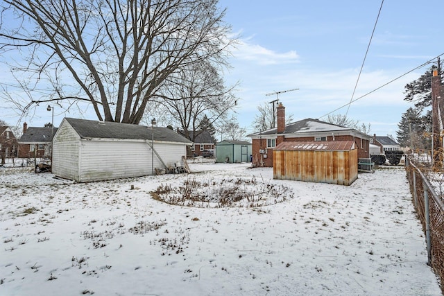 yard layered in snow featuring a shed