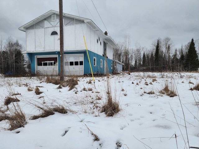 snow covered property featuring a garage