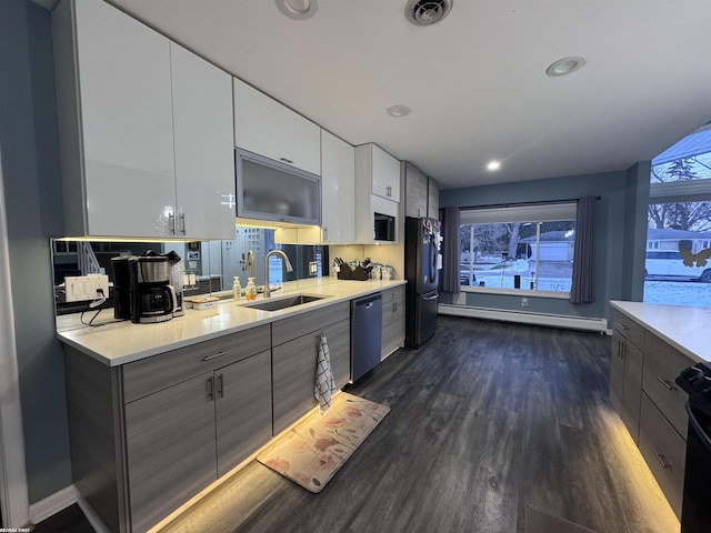 kitchen featuring dishwasher, modern cabinets, freestanding refrigerator, and a baseboard radiator