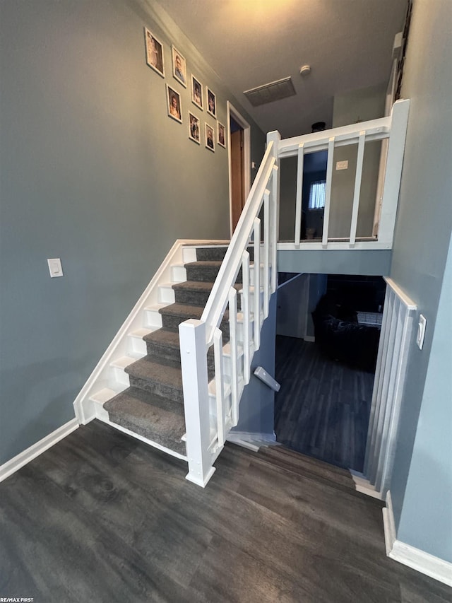 stairway featuring wood finished floors and baseboards