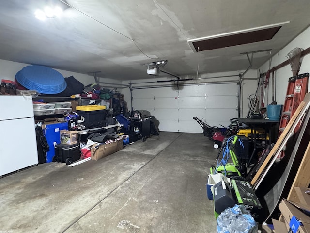 garage with a garage door opener and freestanding refrigerator