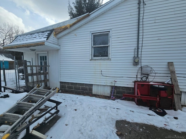 view of snow covered back of property