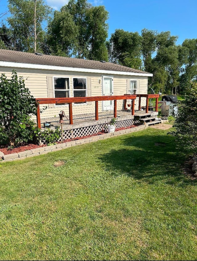 view of front of property featuring a front yard and a deck