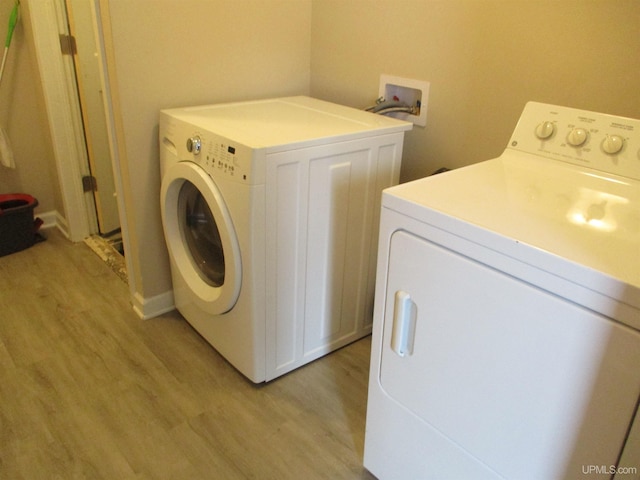 washroom with light wood-type flooring and washing machine and clothes dryer