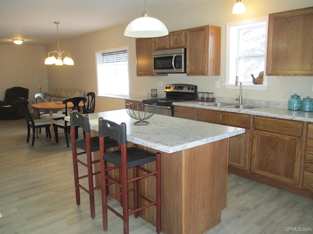 kitchen featuring sink, a center island, hanging light fixtures, and stainless steel appliances