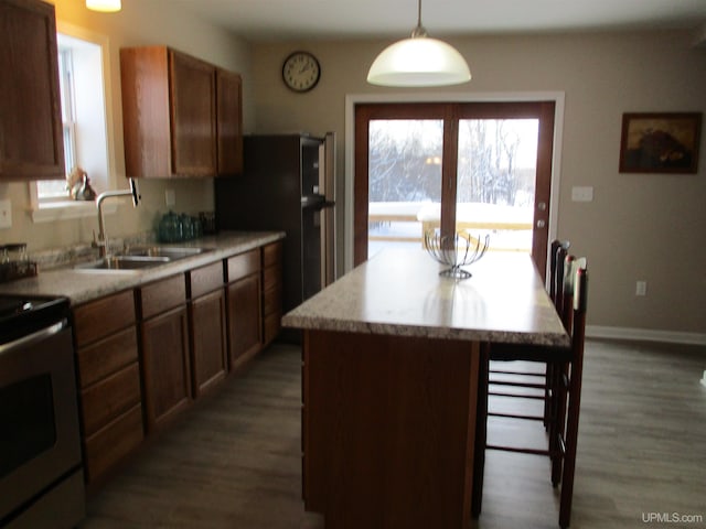 kitchen with a center island, hanging light fixtures, sink, electric range, and dark hardwood / wood-style floors