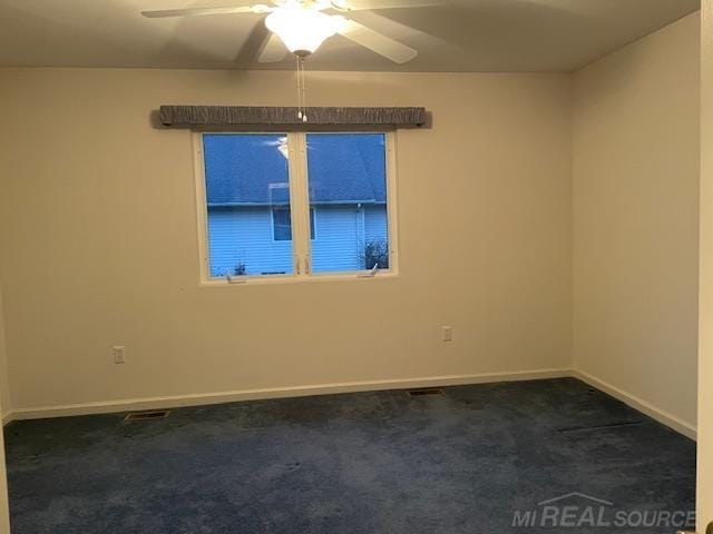 carpeted spare room featuring ceiling fan