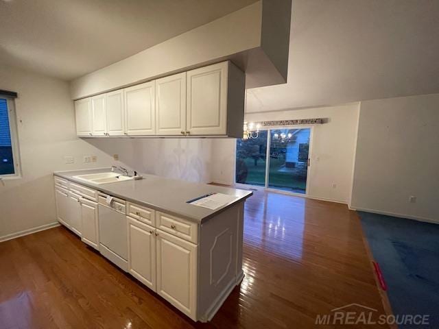 kitchen featuring dishwasher, white cabinets, sink, kitchen peninsula, and dark hardwood / wood-style flooring