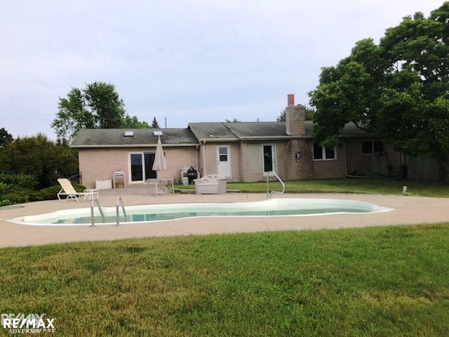 view of swimming pool with a yard