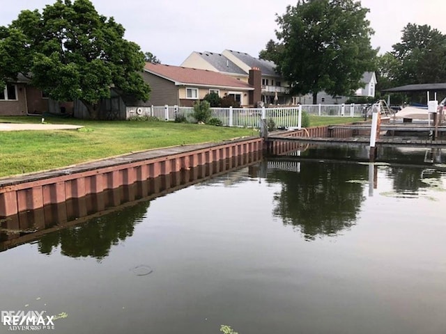 view of dock featuring a water view and a lawn