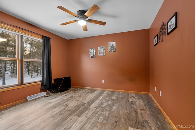 spare room with hardwood / wood-style flooring and ceiling fan