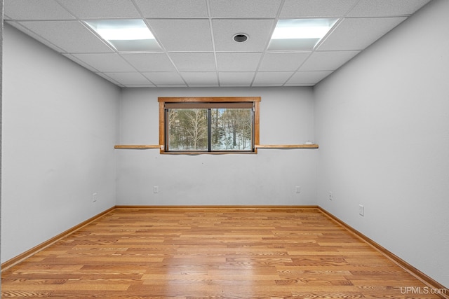 unfurnished room with light hardwood / wood-style floors and a paneled ceiling