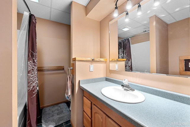 bathroom featuring vanity, walk in shower, and a paneled ceiling