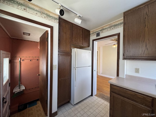 kitchen with white refrigerator and dark brown cabinets