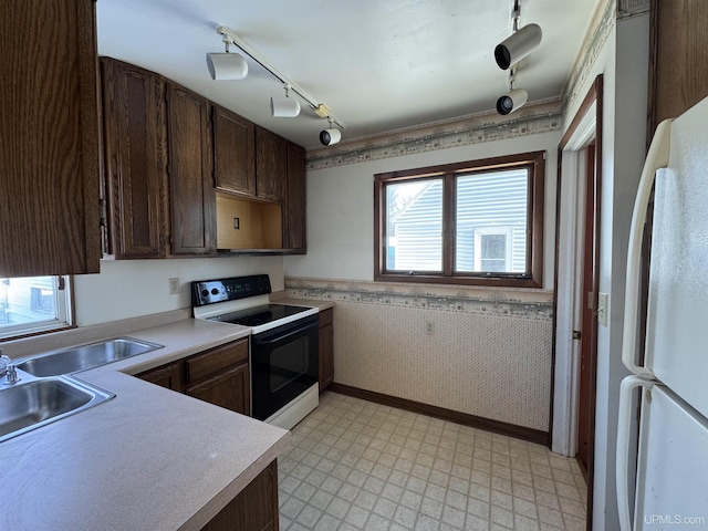 kitchen with sink, range with electric stovetop, dark brown cabinetry, and white fridge