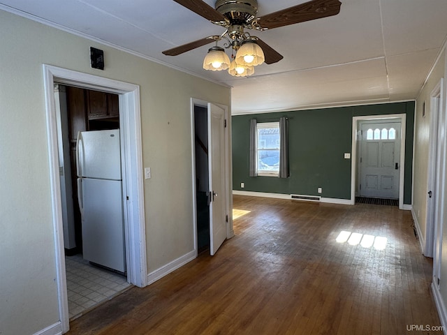 entrance foyer with hardwood / wood-style floors, ceiling fan, and ornamental molding