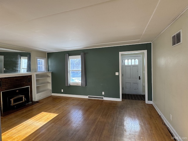 foyer entrance with a brick fireplace and hardwood / wood-style floors