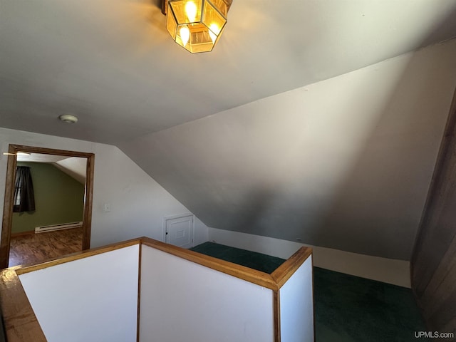 stairway with hardwood / wood-style flooring, a baseboard radiator, and lofted ceiling